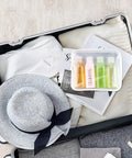 Leakproof Travel Bottles 4 Pack 3.4 Oz TSA Approved Squeeze Containers in suitcase with hat and clothes