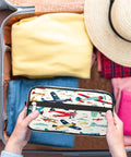 Person packing Cartoon Colorful Airplane Travel Makeup Bag For Women And Men Large Cosmetic Wash Bag into a suitcase