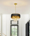 Black and gold chandelier with teardrop crystals hanging in a bright modern room