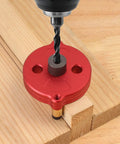 Self Centering Dowel Jig With Swap In Bushings For Knockout Precision Portable Guide Tool on wood with drill bit, showcasing red aluminum design.