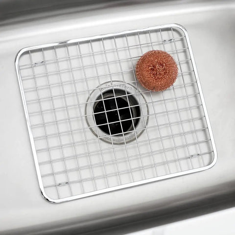 Stainless Steel Sink Grid Protector Kitchen And Bath Rugged Dish Rack in a sink with a scrub pad on top, 12.75x11 inches.
