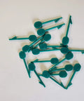 Scattered green nylon pins from Heavy Duty 100 Pack Nylon Pins For Poultry Blinders And Peepers Attachments To Nostrils With Super Strength