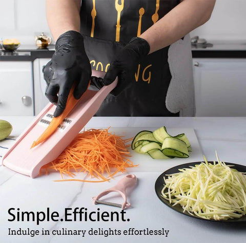 Pink NACOLUS 5-in-1 mandoline slicer for vegetables being used to julienne carrot strips on a kitchen counter