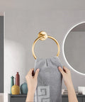 Slick Wall Mounted Towel Ring Crafted From Premium Stainless Steel Tailored For Top Shelf Bathrooms And Kitchens Boasts A Butter Smooth Swivel Handle With Quick Screw Install That Totally Slaps Against Tile Work, showing a hand placing a towel.