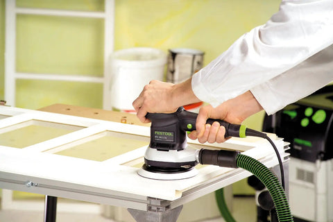 Multi-Jetstream Dust-Free Random Orbital Finish Sander operating on a wood panel with variable speed and soft start features.