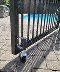 Heavy Duty Spring Loaded Gate Casters, Top Shelf 4 Inch Rubber Swivel Wheels For Wooden Fences And Gates, 250 Pound Load Capacity, Smooth black caster under a gate.