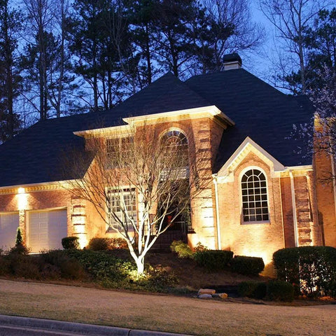 Large house with Ultra Bright Solar Spotlight 200 Lumen With 270 Degree Adjustable Waterproof Outdoor Landscape Light illuminating facade