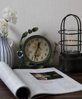 Industrial Table Lamp With Touch Control And 3 Way Dimming on a desk with a clock, vase, and open book