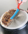 Heavy Duty Stainless Steel Wire Brush for cleaning metal rust removal and paint scrubbing with rubber covered handle in use on grimy pan