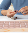 Person threading beads in Straight Up Premium Pine Wood Jewelry Tray With 24 Compartments And Plush Velvet Lining To Store Your Bling.