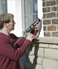 Person applying Beige Window Door And Siding Sealant 10 Oz Tubes Advanced Formula Weatherproof Exterior Caulk on brick wall