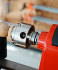 Lathe thread adapter, 1x8 TPI female to 1-1/4x8 TPI male, chrome with jackscrews, installed on red headstock spindle.