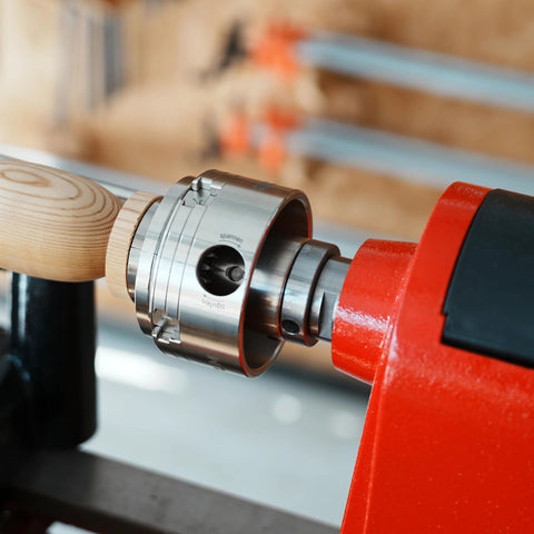 Lathe thread adapter, 1x8 TPI female to 1-1/4x8 TPI male, chrome with jackscrews, installed on red headstock spindle.