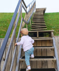 Child climbing stairs with Non Slip Outdoor Stair Treads 6x24 Inches Black 8 Pack Pre Cut 80 Grit Anti Slip Grip Tape Heavy Duty Traction Strips