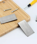 Six Pack Of Steel Flange Wedges With Beveled Right Angle Shims For Welding Machines And Lathes on a wooden board