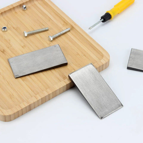Six Pack Of Steel Flange Wedges With Beveled Right Angle Shims For Welding Machines And Lathes on a wooden board