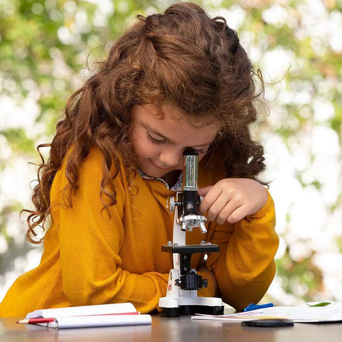 Girl using the Rock Solid 1200X Monocular Compound Microscope With Killer LED Lighting And A Straight Up 52 Piece Science Starter Kit for biology.