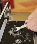 Close-up of Built Tough Heavy Duty Four Post Router Lift being adjusted with a wrench for precise height control in woodworking.