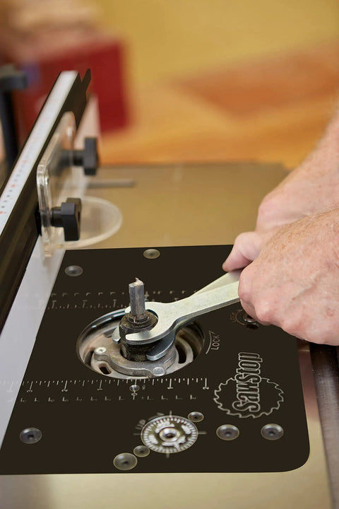 Close-up of Built Tough Heavy Duty Four Post Router Lift being adjusted with a wrench for precise height control in woodworking.