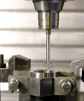 Carbide end mill (1/8 in shank) upcut router bit, single-flute, mounted in milling vise