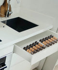 Coffee Pod Drawer Organizer For Nespresso VertuoLine Holds 30 Pods, clear acrylic insert in a kitchen drawer next to a sink.