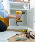 Person using a drill to install Premium 304 Stainless Steel Phillips Pan Head Machine Screws Assortment 300 Pcs in a cabinet.