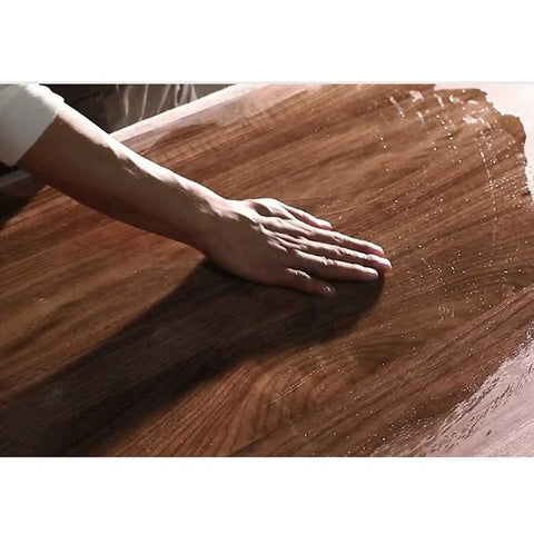 Hand running over the smooth surface of the Straight Up Solid Wood Electric Standing Desk With Drawers.