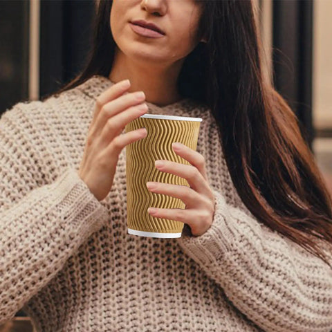 Woman holding 90 Pack 16 Oz Disposable Coffee Cups No Lids Insulated Ripple Wall Champagne Corrugated Paper Cups Go To Coffee Hot Chocolate Tea On The Go Travel Office Home For Catering And Office Use