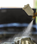 Heavy Duty Forged Spray Gun With 1.3 Mm Tip And Stainless Needle Featuring Air Curtain Design spraying paint in workshop.