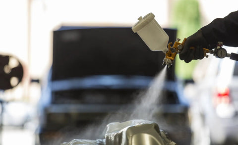 Heavy Duty Forged Spray Gun With 1.3 Mm Tip And Stainless Needle Featuring Air Curtain Design spraying paint in workshop.