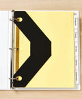 Triangle Shaped Sheet Lifters For 3 Ring Binders, Black, Pack Of 2, showing insertion in binder with tabs visible