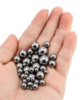 Hand holding 500 piece bicycle bearing balls kit with eleven sizes, precision steel balls for bearings, perfect for bike hubs and DIY fixes.