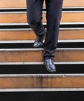 Person walking down stairs with Heavy-Duty Anti-Slip Tape 18 In By 40 Ft For Indoor Outdoor Use On Ramps Stairs Garage Floors Warehouses And Workshops Black Abrasive Non-Slip Grip Roll applied on steps.