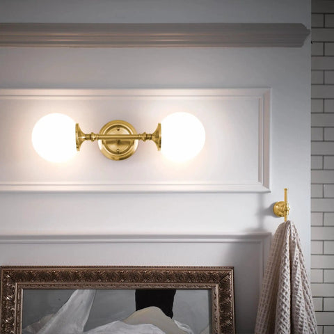 Colinet Double Robe Hook In Brushed Gold For Bath And Kitchen holding towel next to vintage wall mirror in bathroom.