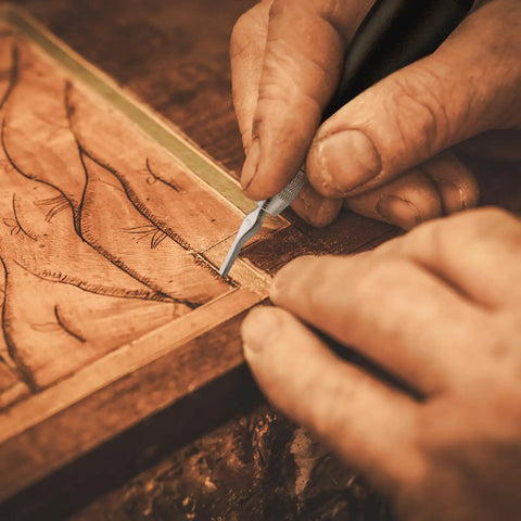 Hands using a tool from 12 Pack Linoleum Cutter Kit For Block Printing And Linocut on a woodblock.