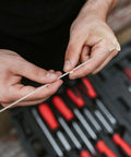 Hands holding Sturdy Metal Binding Pin For Office And School Use Precise File Aligning Locating Pin against toolset background