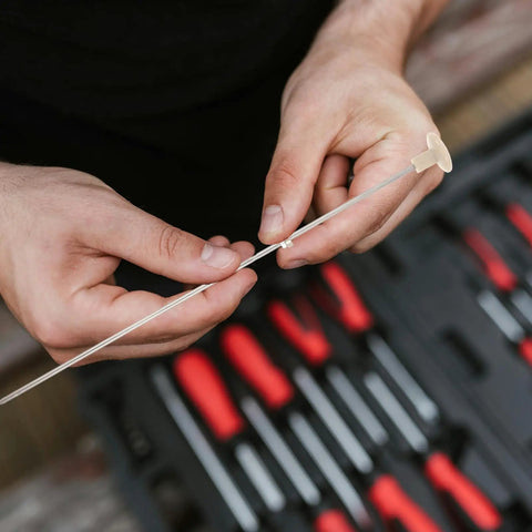 Hands holding Sturdy Metal Binding Pin For Office And School Use Precise File Aligning Locating Pin against toolset background