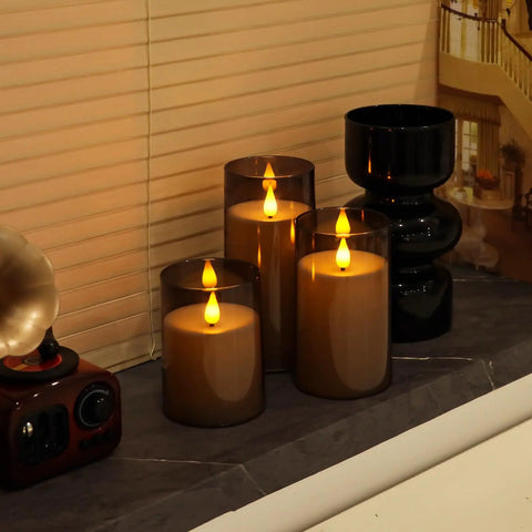 Grey Flameless Pillar Candles With Remote Control And Timer Battery Operated LED Candles Featuring Realistic 3D Flame Perspex Construction Pack Of 3 In D 3 Inch By H 4 Inch 5 Inch And 6 Inch Heights on a windowsill
