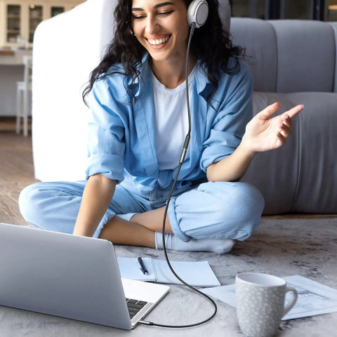 Woman sitting on floor with headphones, using Premium 3.5 Mm Aux Extension Cable Three Pole Trs Headphone Extender Cord 3.3 Feet.