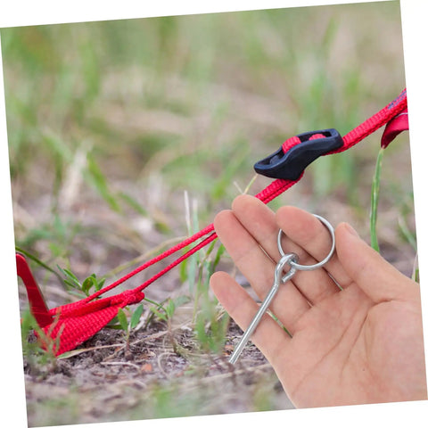 Hand holding a connector for 10 Pack Galvanized Tent Pole Connectors For Quick Setup And Lightweight Repair Camping Must Haves For Hiking And Outdoor Adventures Durable Easy To Use Keeps Shelters Secure next to tent ropes on the ground.
