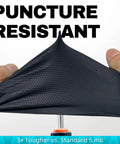 Demonstration of 8 Mil Nitrile Disposable Gloves' puncture resistance and diamond texture by stretching over a tool, black color.