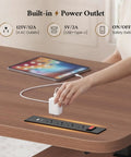Hustle Ready L Shaped Electric Standing Desk Height Adjustable Executive Table With Walnut Finish showing built-in power outlet.