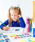 Girl writing in notebook at desk with 160 Ocean Animals Name Tag Stickers Set With Eight Cute Sea Creature Designs on side