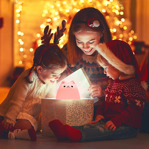 Children excitedly opening a gift box with LED Cat Night Light For Kids Battery Powered Silicone Cat Nursery Night Light glowing inside.
