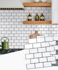 Thick Peel And Stick Backsplash Tiles In White Subway Style For Kitchen 10 Sheets Of 12 By 12 Inches 2mm To 2.5mm Thick Durable Self Adhesive DIY Friendly Easy Install Covers 40 Percent More Area displayed on a kitchen wall with stove and shelf.