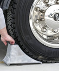 Person using Beefy Aluminum Wheel Chock With Rugged Teeth For Extra Grip And Stability Steep Slope Design 55000 Lb Capacity Heavy Duty Parking Tool For Trucks And Rigs 6.25 X 12.25 X 7 Inch Silver on truck.