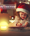 Child writing beside rechargeable mushroom night light with tap and remote control cordless multicolor LED nightlight dimmable silicone nursery lamp for breastfeeding and sleep portable baby bedroom light kid friendly.