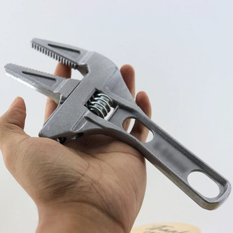 No Hassle Adjustable Short Handle Bath Wrench held in hand showing ergonomic design and wide jaw for bathroom fixtures.