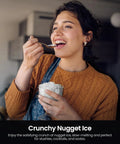 Kismile Nugget Ice Maker countertop appliance, silver finish; person enjoys crushed ice in a glass