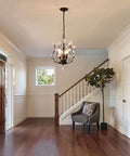 Vintage K9 Clear Crystal 3-Light Pendant Ceiling Fixture In Black Finish hanging in a modern foyer with a staircase.